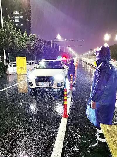 凌晨，東甌大橋卡點(diǎn)處，永嘉縣黨員干部頂風(fēng)冒雨、在嚴(yán)寒中牢牢值守。（　圖片由浙江省溫州市委組織部提供）